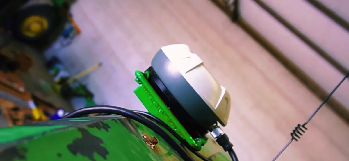 FJD GNSS receiver mounted on the roof of a John Deere tractor cab